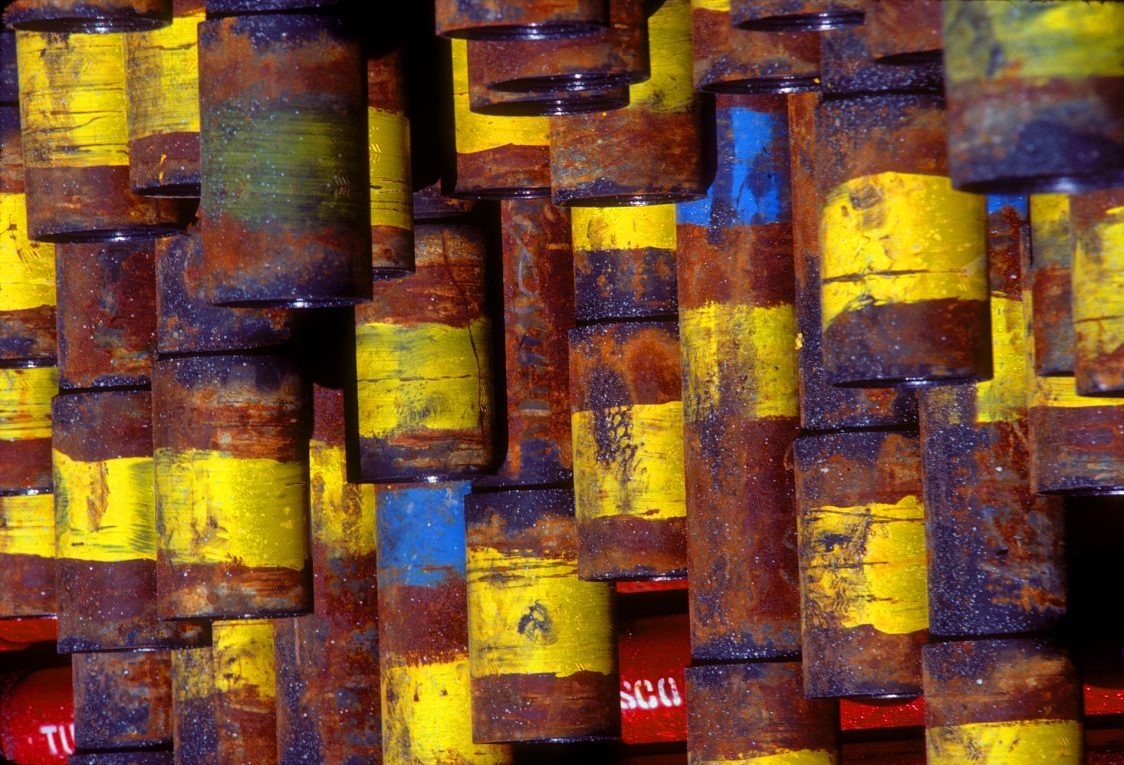 Coated pipes intertwined against weathered timber decking