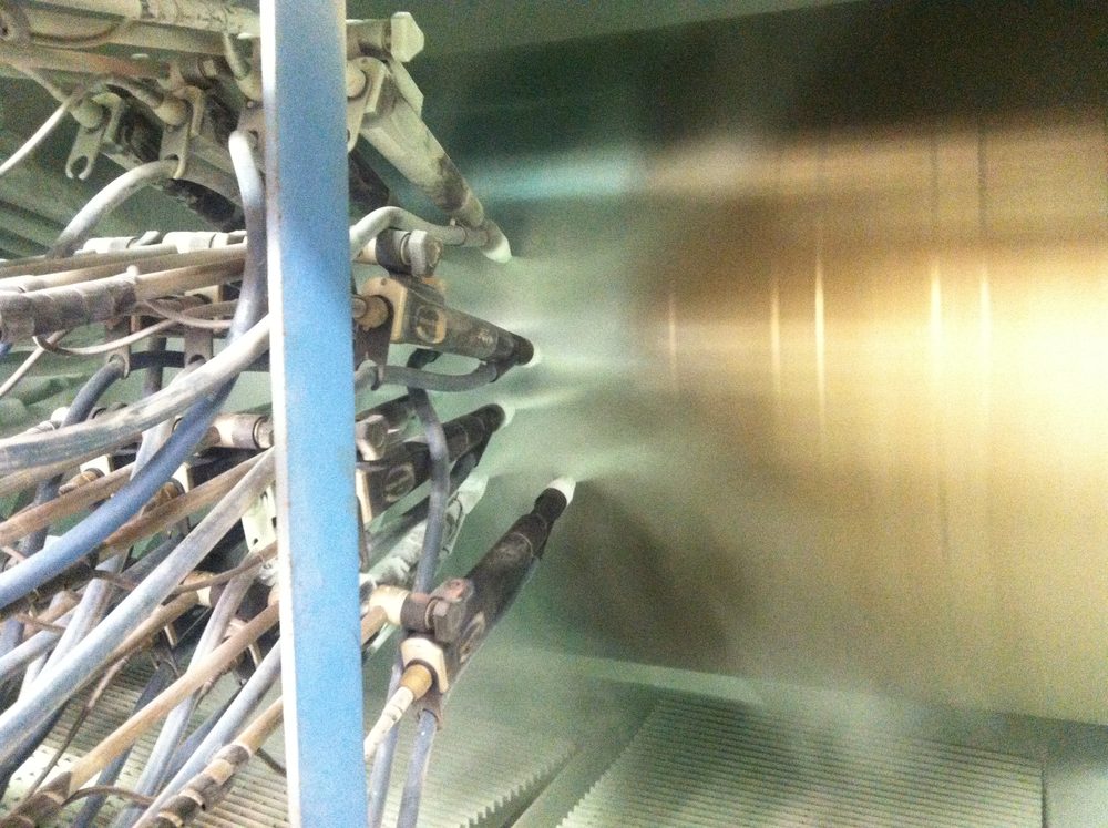 Spray application of protective coating to pipe