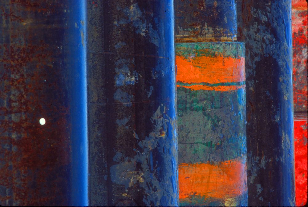 Pipe surfaces in cobalt blue and orange with weathered paint