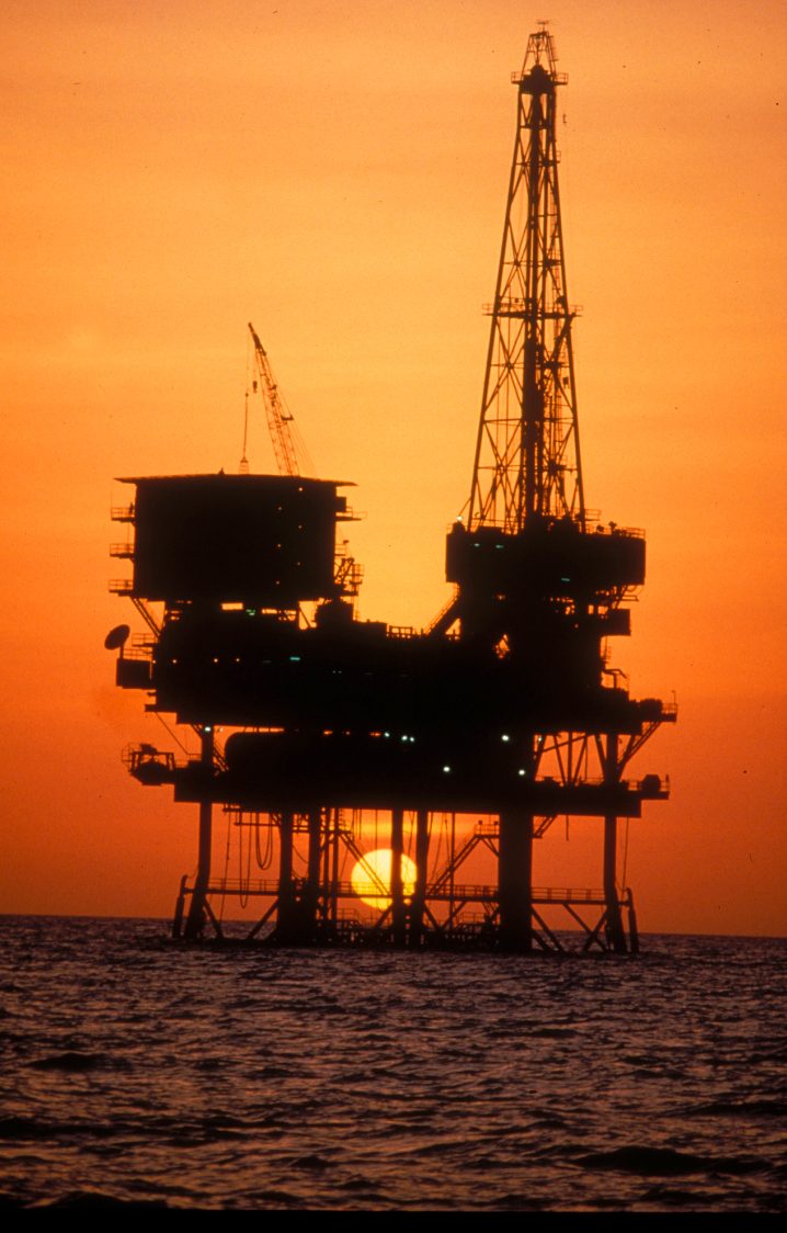 Offshore platform silhouette against orange sky