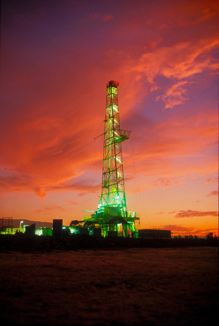 Illuminated rig against a red evening sky